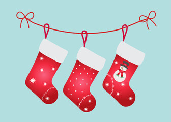 Christmas stockings with various traditional colorful holiday ornaments. Hanging children clothing elements with cute xmas patterns on rope. Red socks with snowflakes, snowman, christmas