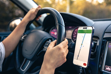 Woman using navigation app on smartphone while driving a car.