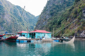 Squid boat with powerful bulbs outside the floating houses at the Cua Van floating village, Halong...