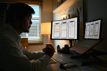 Fototapeta na wymiar Focused male developer working on development project for mobile application at home office