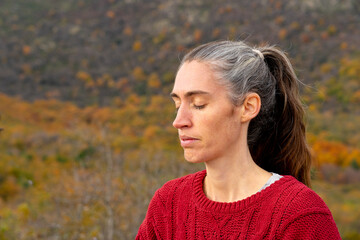 Middle aged woman meditating in nature