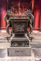 Incense burning in a bronze urn at Văn Miếu Quốc Tử Giám (Temple of Literature) in Hanoi, Vietnam