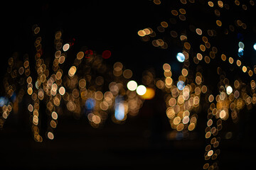 Blurred holiday background with bokeh. Defocused New Year and Christmas illumination.