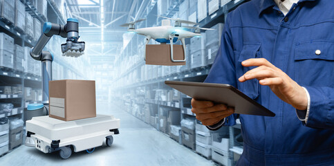 Manager with digital tablet in an automated warehouse with robots and drones.