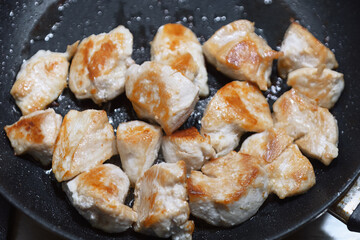 Chicken fillet fried in a frying pan, close-up. Details of the cooking process