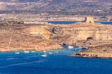 Boats gather at the Blue Lagoon on Comino island between Gozo and Malta where the water is a beautiful blue colour.