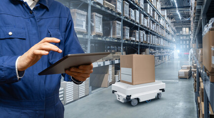 Warehouse manager with digital tablet controls robot with a package. Unmanned delivery concept.