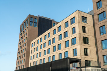 Obraz premium An example of minimalistic, cubic-shaped architecture with a view of the decorative decoration of the building facade. View of buildings from a low angle against a clear blue sky.