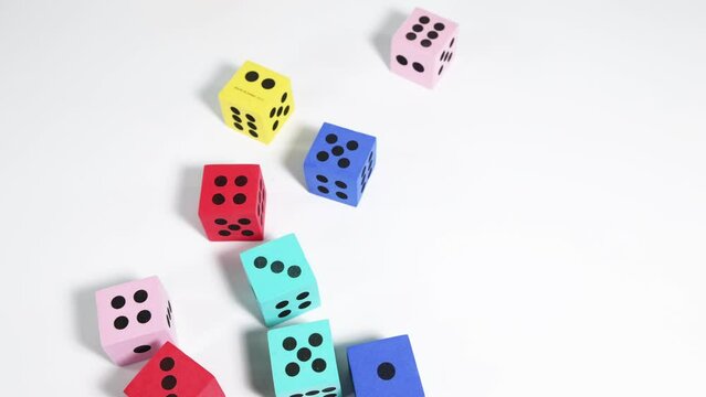 A close-up view of a handful of colorful dice being rolled.