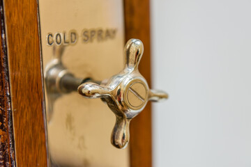 Tap on an old fashioned shower unit labeled 