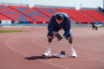 Disabled athletes prepare in starting position ready to run on stadium track