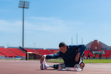 Disabled athletic man stretching and warming up before running on stadium track