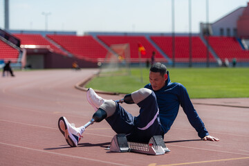 Disabled athletic man stretching and warming up before running on stadium track