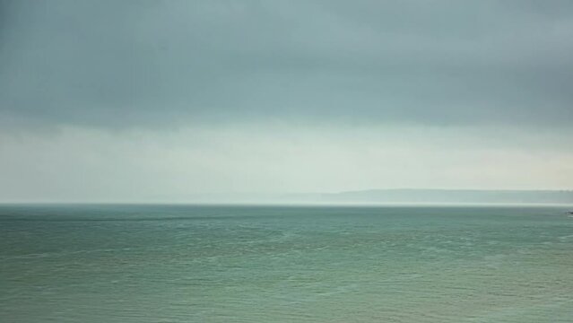 Timelapse of heavy squall developing over water, land just visible in the background