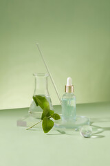 A bottle of hydrating serum is placed on a glass podium with green tea leaves, an Erlenmeyer flask and a glass wand on a minimalist background. Copy space for cosmetics advertising.