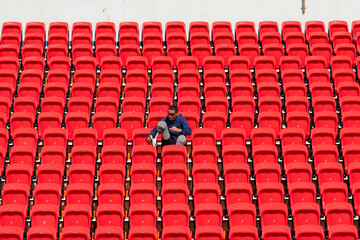 Fototapeta premium Disabled athletes in a blue shirt sitting on the red seats at the stadium, Prepare for running training.