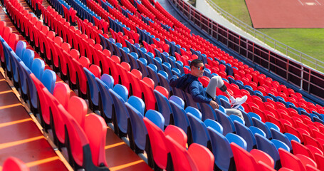 Naklejka premium Disabled athletes prepare their bodies on amphitheater in a sports arena on a sunny day before entering a short-distance running competition