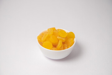 Yellow Apricot or yellow dry fruits on white bowl with white background, Yellow Apricot or yellow dry fruits scattered on white bowl with white background