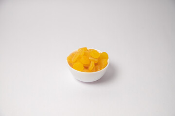 Yellow Apricot or yellow dry fruits on white bowl with white background, Yellow Apricot or yellow dry fruits scattered on white bowl with white background