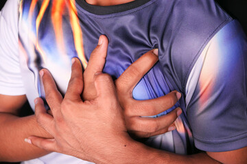 young man suffering pain in heart and holding chest with hand