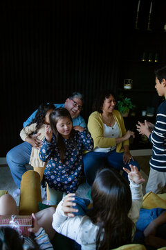 Big happy family sitting in living room and playing games with hands daughter with down syndrome