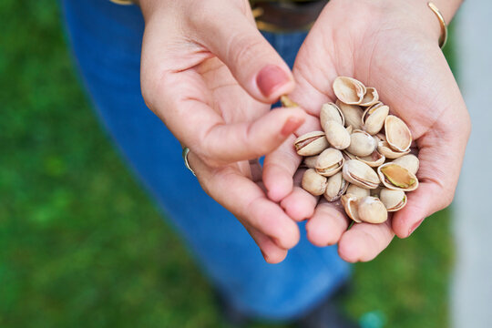 Woman eats pistachios next to lavender closeup with hand 