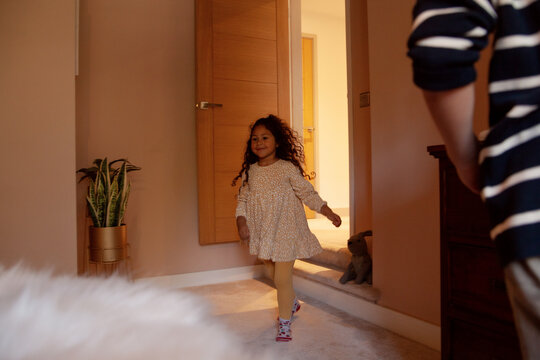 Little girl in yellow dress in bedroom running and smiling