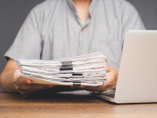 Businessman holding a pile of documents while sitting at the table