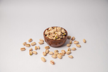 Pistachios or salt Pista on white bowl with white background, Pistachios or salt Pista scattered on...