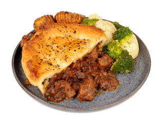 Steak pie with rich all butter puff pastry meal with hasselback potatoes, broccoli and cauliflower isolated on a white background