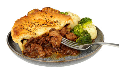 Steak pie with rich all butter puff pastry meal with hasselback potatoes, broccoli and cauliflower isolated on a white background