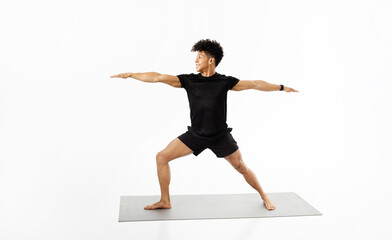 fitness instructor guy demonstrating yoga warrior pose over white background