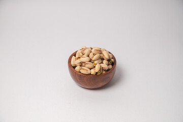 Pistachios or salt Pista on white bowl with white background, Pistachios or salt Pista scattered on...