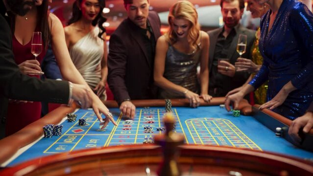 Slow Motion Footage of a Spinning Roulette Wheel. Focus Switching to Female and Male Guests Placing Risky Bets while Playing Roulette. Crowd Celebrating a Positive Outcome and Cheering the Winners