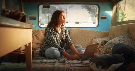 Independent Empowered Travel Blogger Writing a Blog Article on Her Laptop Computer While Camping in...