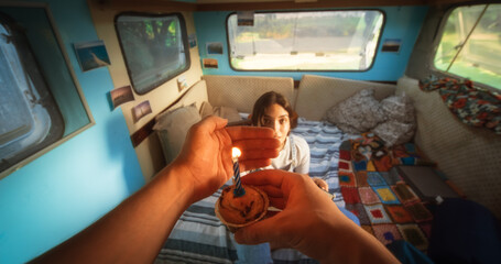 Caring Partner Bringing a Birthday Cupcake Muffin with a Candle to His Beautiful Young Girlfriend. Loving Tourist Couple Living in a Caravan, Road Tripping Across the Country and Camping. POV Shot