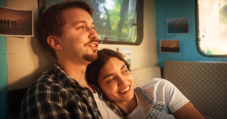 Close Up Portrait of a Young Loving Couple Enjoying Time Together, Cuddling and Chatting in a Cozy Motorhome. Adventurous Man and Female Travelling, Camping in a Caravan and Enjoying Nomad Lifestyle