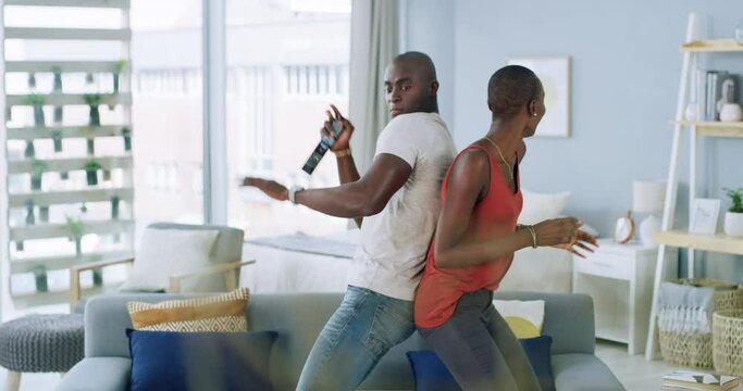 Happy, dance and couple in a living room with love, energy and movement, fun and bonding in their home. Freedom, rhythm and black people in a lounge with music, celebration or dancing on vacation