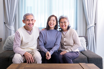Portrait of Asian family consist of senior father mother and daughter sitting together with happy...
