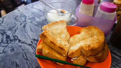 Common oriental breakfast set in Malaysia consisting of coffee, nasi lemak, toast bread and half-boiled egg, Breakfast toast set with coffee and toast bread with butter and kaya, a typical breakfast 