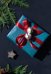 Christmas concept composition with gift box on the dark blue wooden background. Winter holiday greeting card. 