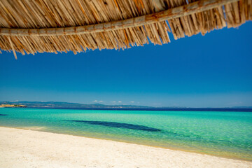 Fototapeta na wymiar Turquoise water beach and umbrella