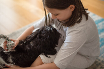 Girl with a dog. 9-Year-Old Girl Playing with Her Small Dog at Home