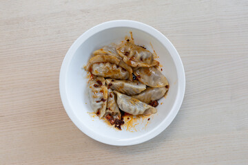 A bowl of spicy dumplings.