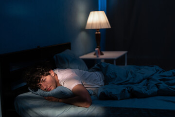 Arab man suffering from insomnia lying in bed with open eyes. Handsome guy in bed sleep disorder...