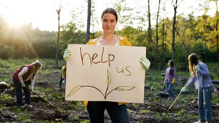 Woman eco activist protesting against Earth planet pollution. Caucasian volunteer with poster with...