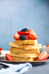Waffles and Strawberries stacked on a plate. Belgian homemade waffles