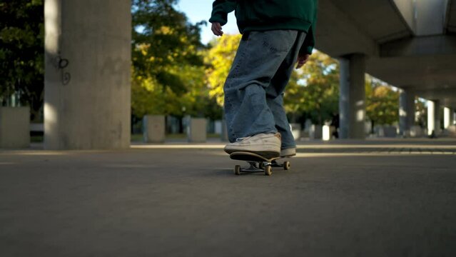 Close-up view of a talented man practicing skateboard rides on a city street parking place
