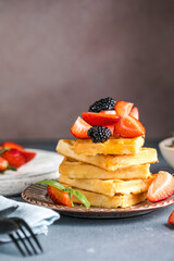 Waffles and Strawberries stacked on a plate. Belgian homemade waffles