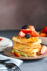 Waffles and Strawberries stacked on a plate. Belgian homemade waffles